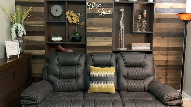 A modern living room with a leather sofa, wooden shelves, and decorative items. - World’s Fair Charm -Two Story 3 bdrm (St. Louis)
