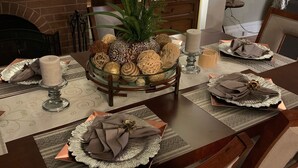 A dining table set with place settings, a centerpiece with decorative items, and a mirror reflecting the room. - World’s Fair Charm -Two Story 3 bdrm (St. Louis)