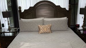 A large bed with a wooden headboard, two bedside tables with lamps, and a window with sheer curtains. - World’s Fair Charm -Two Story 3 bdrm (St. Louis)
