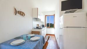 Cafetera o tetera, frigorífico, placa de cocina y utensilios de cocina