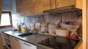 Una cocina con armarios de madera, un lavamanos de acero inoxidable, una estufa y varios alimentos sobre la encimera.