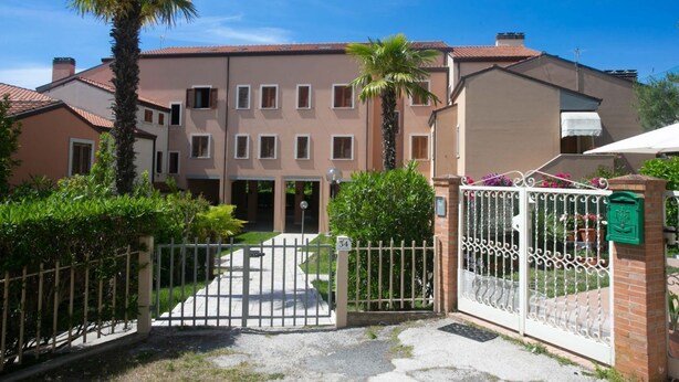 A residential building with a gated entrance, a palm tree, and a mailbox. - N212 - Numana, four-room apartment in the center with terrace (Numana)