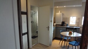 A modern kitchen with a dining area, a built-in oven, and a coffee maker. - "LANDBeautiful beamed apartment in the historic center of Colmar's "Little Venice". (Colmar)