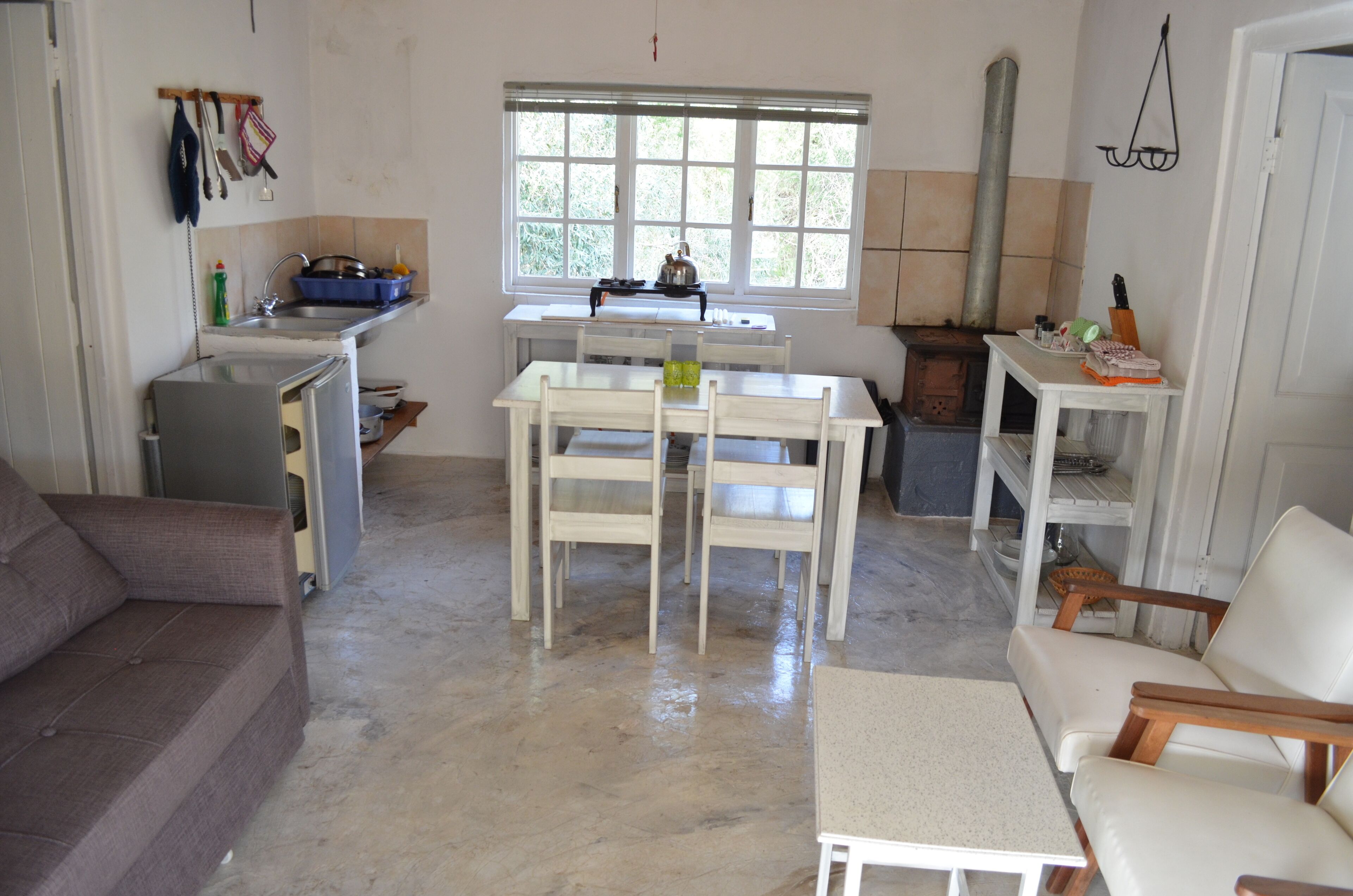 A compact living space with a kitchenette, a dining area, and seating.