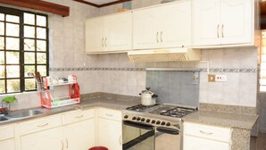 Una cocina con armarios blancos, una estufa a gas y un horno empotrado.