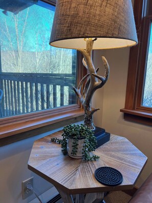 Een tafel met een lamp, een decoratieve plant en een stopcontact.