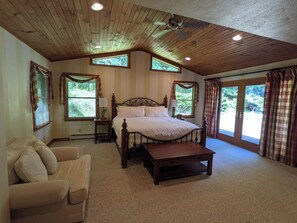 A bedroom with a wooden ceiling, a bed, a nightstand, a chair, and a window with curtains. - Large lodge w/ game room, fire pit + private suite (Slaty Fork)