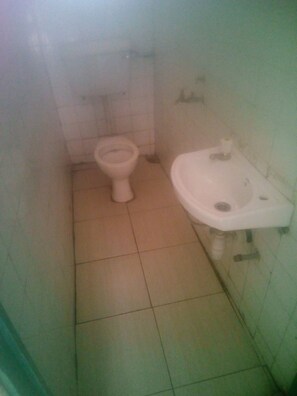 Une petite salle de bain avec des toilettes et un lavabo.