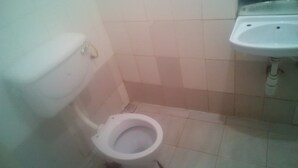 A small bathroom with a toilet and a sink. - Comfy Bar And Restaurant (Nairobi)