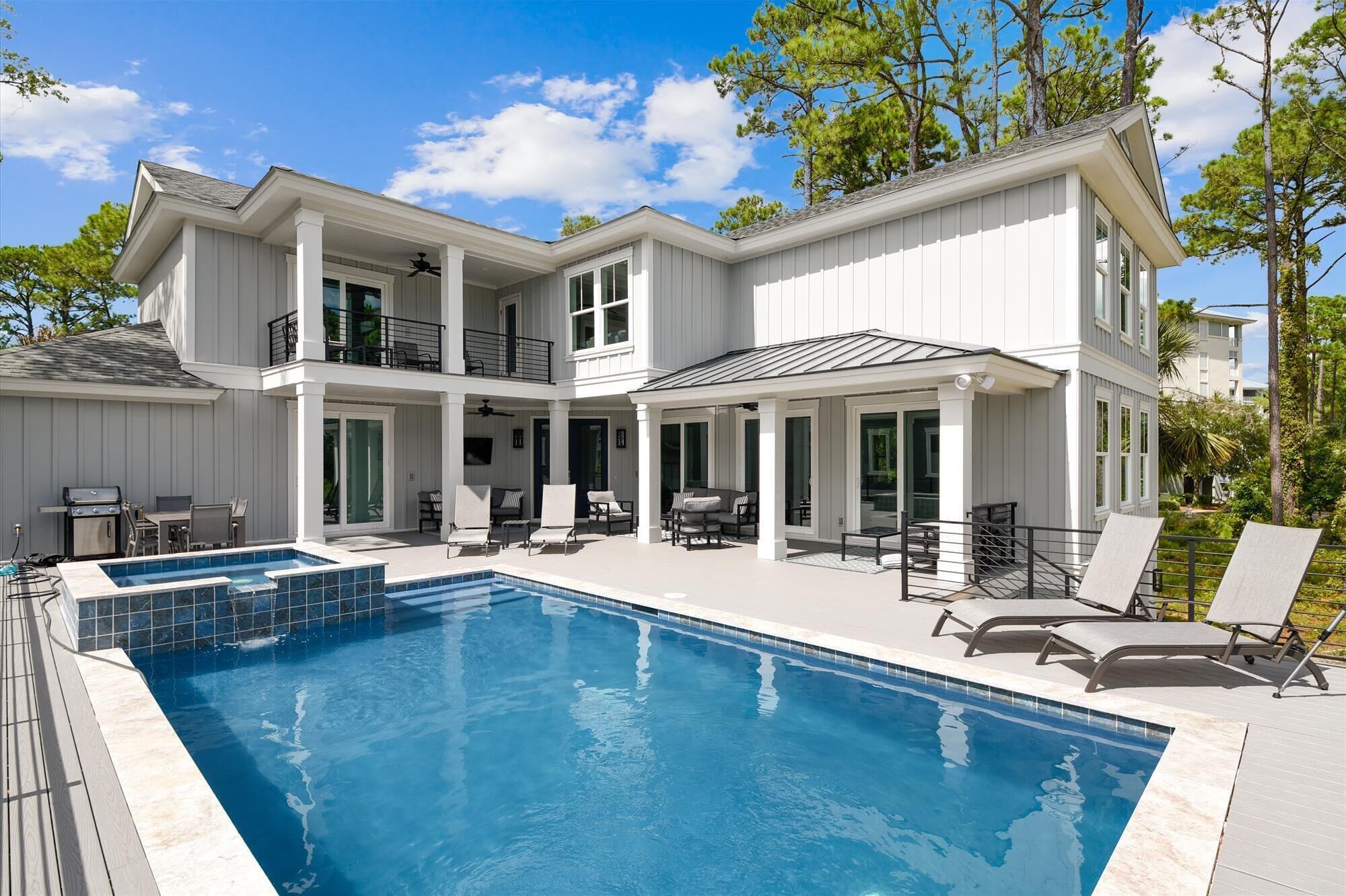 Une maison à deux étages dotée d’une piscine, d’un espace extérieur aménagé et d’un patio couvert.