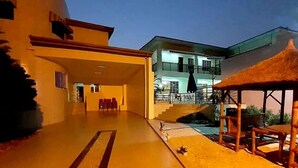A spacious outdoor area with a covered seating area and a pool. - Have'Den Resort-Hôtel (Abidjan)