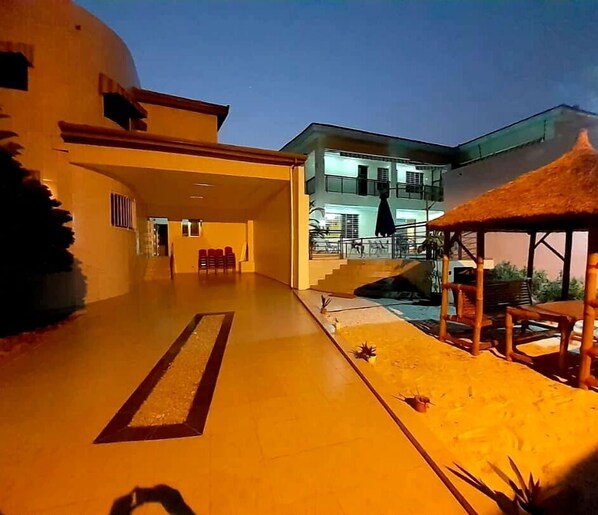 A spacious outdoor area with a covered seating area and a pool.