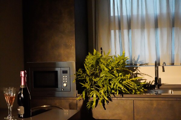 A kitchen with a microwave, a sink, and a potted plant. - Bob W Milan Ticinese (Milan)