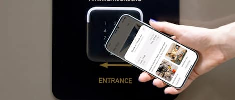 Un dispositivo digital que muestra la interfaz de registro de un hotel, con un teléfono inteligente en la mano.