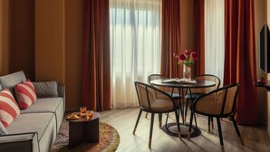Una sala de estar moderna con un sofá, una mesa de comedor, sillas y un televisor.