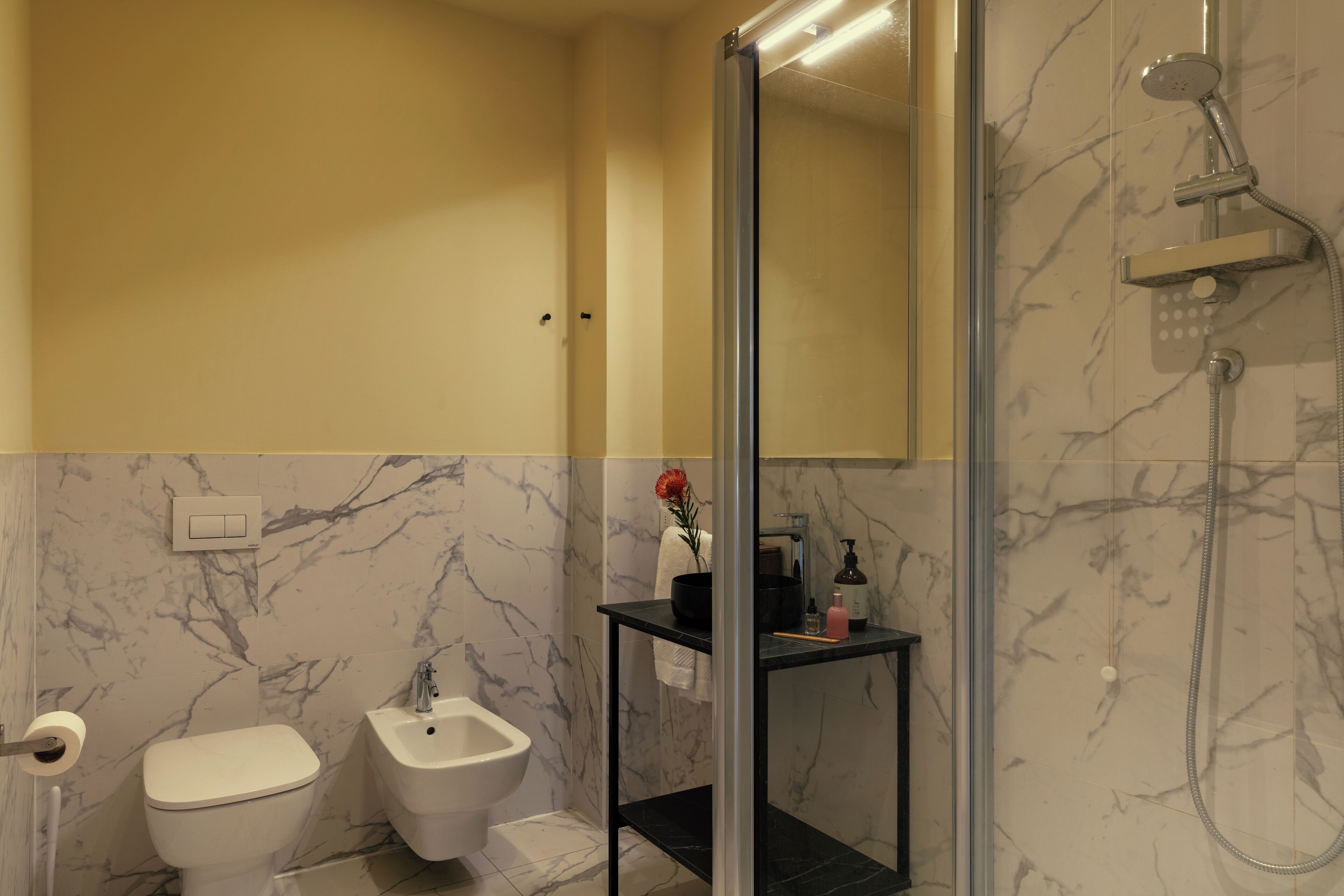 Un baño con inodoro, bidé y zona de ducha.