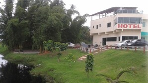 A hotel with a modern design, a parking area, and a small pond. - Hotel KM 73 (Araquari)