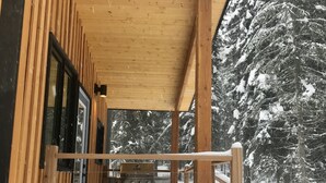 A wooden deck with a grill, surrounded by snow-covered trees. - The Stag Chalet,  new Sauna in the forest! Fast wifi! (Golden)