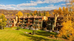 Et boligområde med moderne huse, velplejede græsplæner og træer med efterårsfarver.