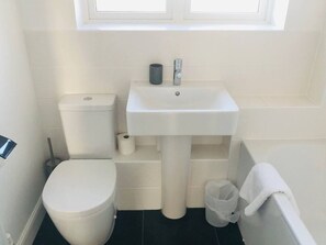 A small bathroom with a toilet, sink, and bathtub.