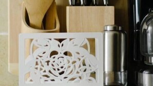 Uma bancada de cozinha com utensílios de madeira, bloco de facas e eletrodomésticos de aço inoxidável.