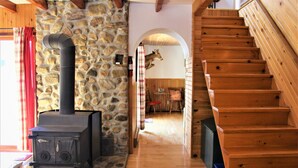 Eine Holztreppe, eine Steinwand und ein Kamin in einem Raum.