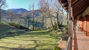 A wooden building with a brick pathway leading to a grassy area with trees and mountains in the background. - Architect's house not overlooked in the Ossau valley, spa & sauna, 7000m2 park (Béost)