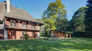A two-story house with a balcony, a chimney, and a well-maintained lawn. - Architect's house not overlooked in the Ossau valley, spa & sauna, 7000m2 park (Béost)
