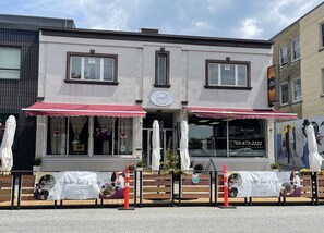 A restaurant with a red awning and a sign that reads "Wander Food & Wine."