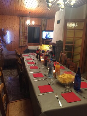 A dining area with a long table set for a meal, wooden walls, a television, and a fireplace. - GRAND CHALET 400m FROM THE FOOT OF THE SLOPES LABRESSE-HOHNECK (La Bresse)