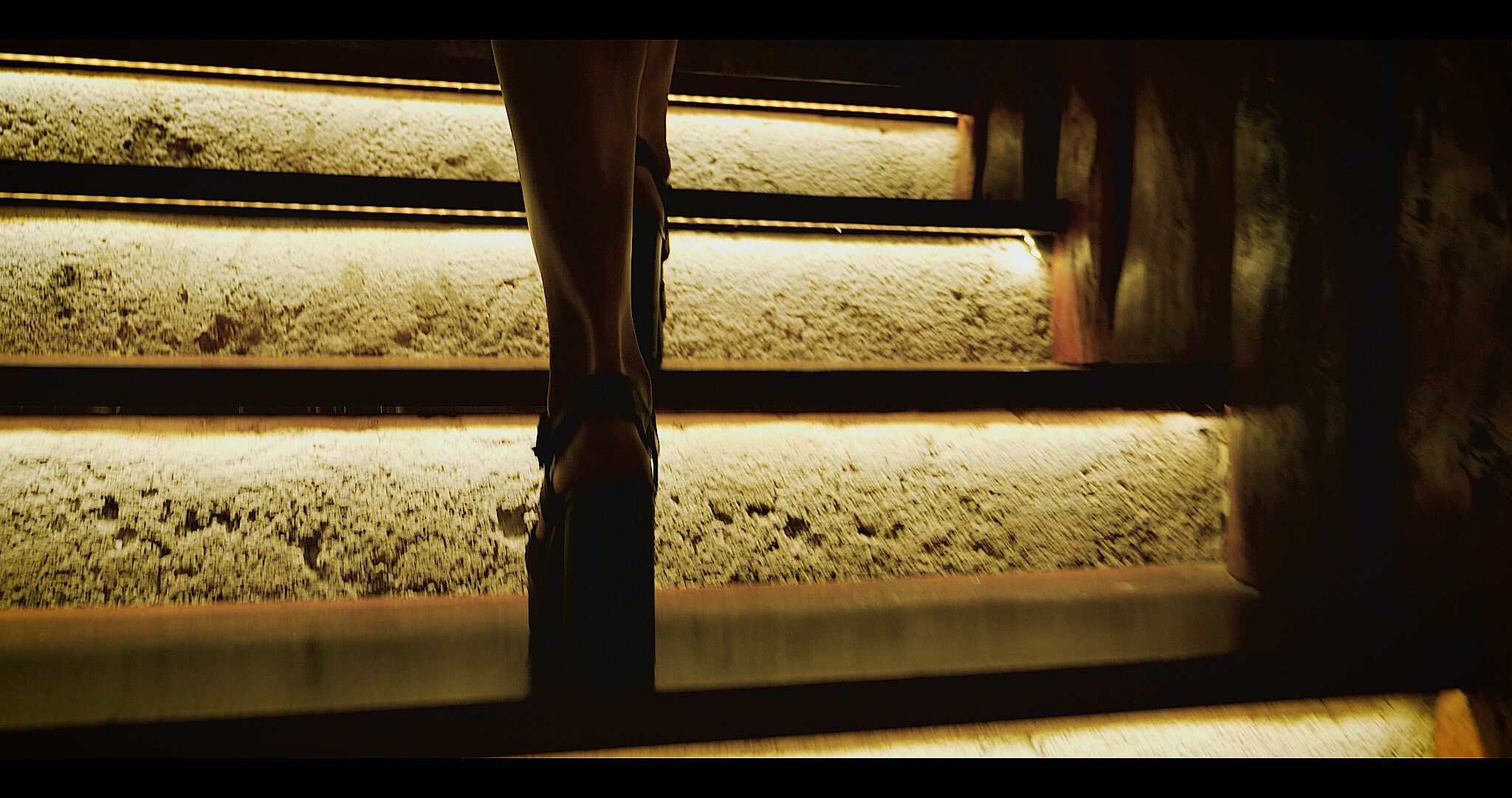 A person standing on a staircase with illuminated steps.