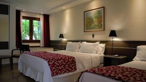 A hotel room with two beds, a window with curtains, a painting on the wall, and two bedside lamps. - Los Espinillos Hotel & Spa (Villa Carlos Paz)