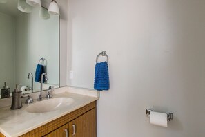 Een bad/douchecombinatie, een haardroger, handdoeken, zeep