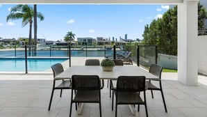 Een terras met zwembad, buitenmeubels en uitzicht op de stad.