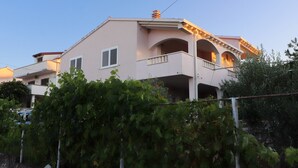 Ein zweistöckiges Gebäude mit Balkon und Schornstein.
