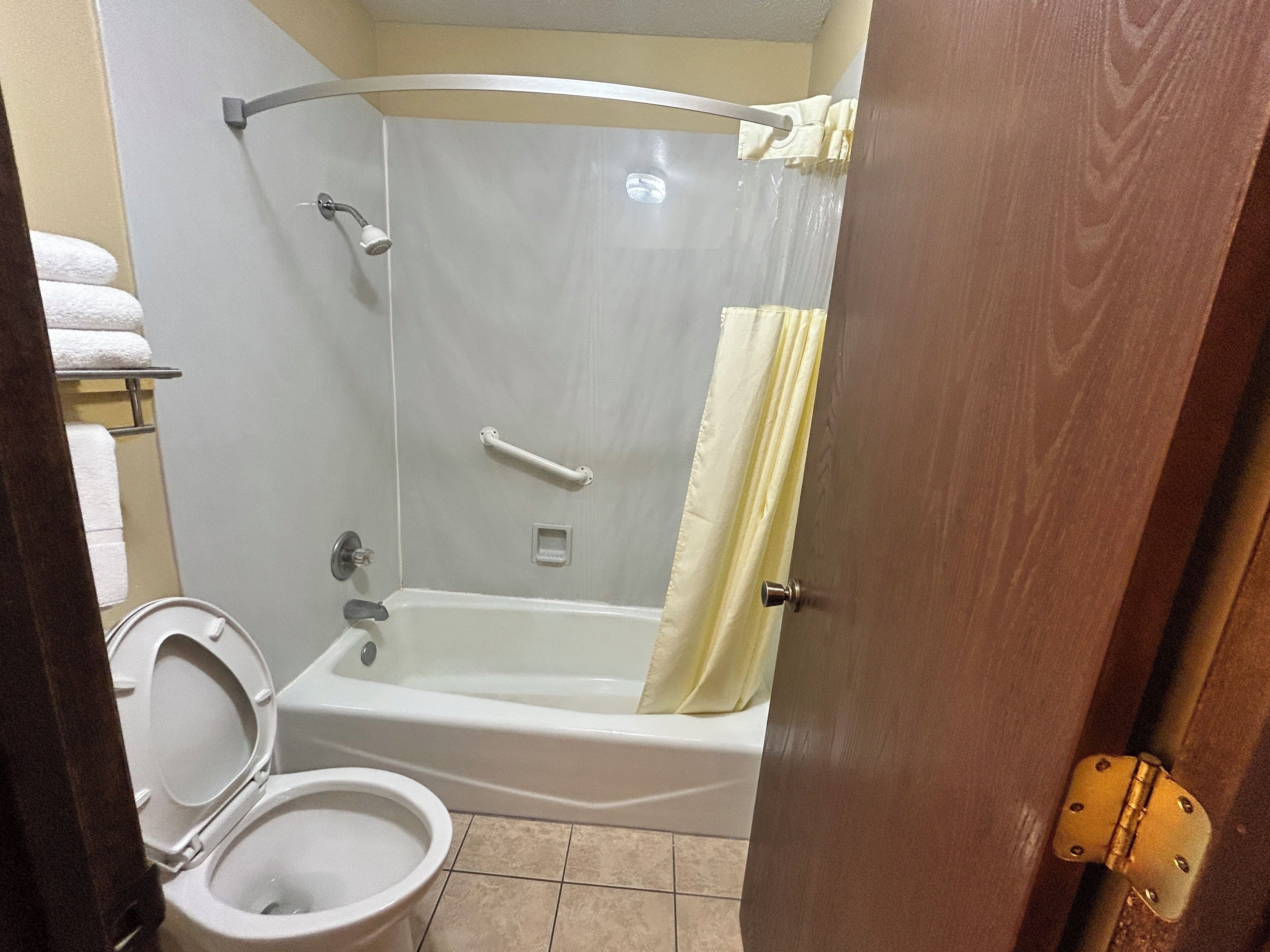 A bathroom with a shower, toilet, and bathtub.