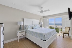 A bedroom with a bed, nightstands, a ceiling fan, a chair, and a view of the ocean. - Stunning Gulf Front Townhome direct gulf front views! Fall Sale! (Sanibel)