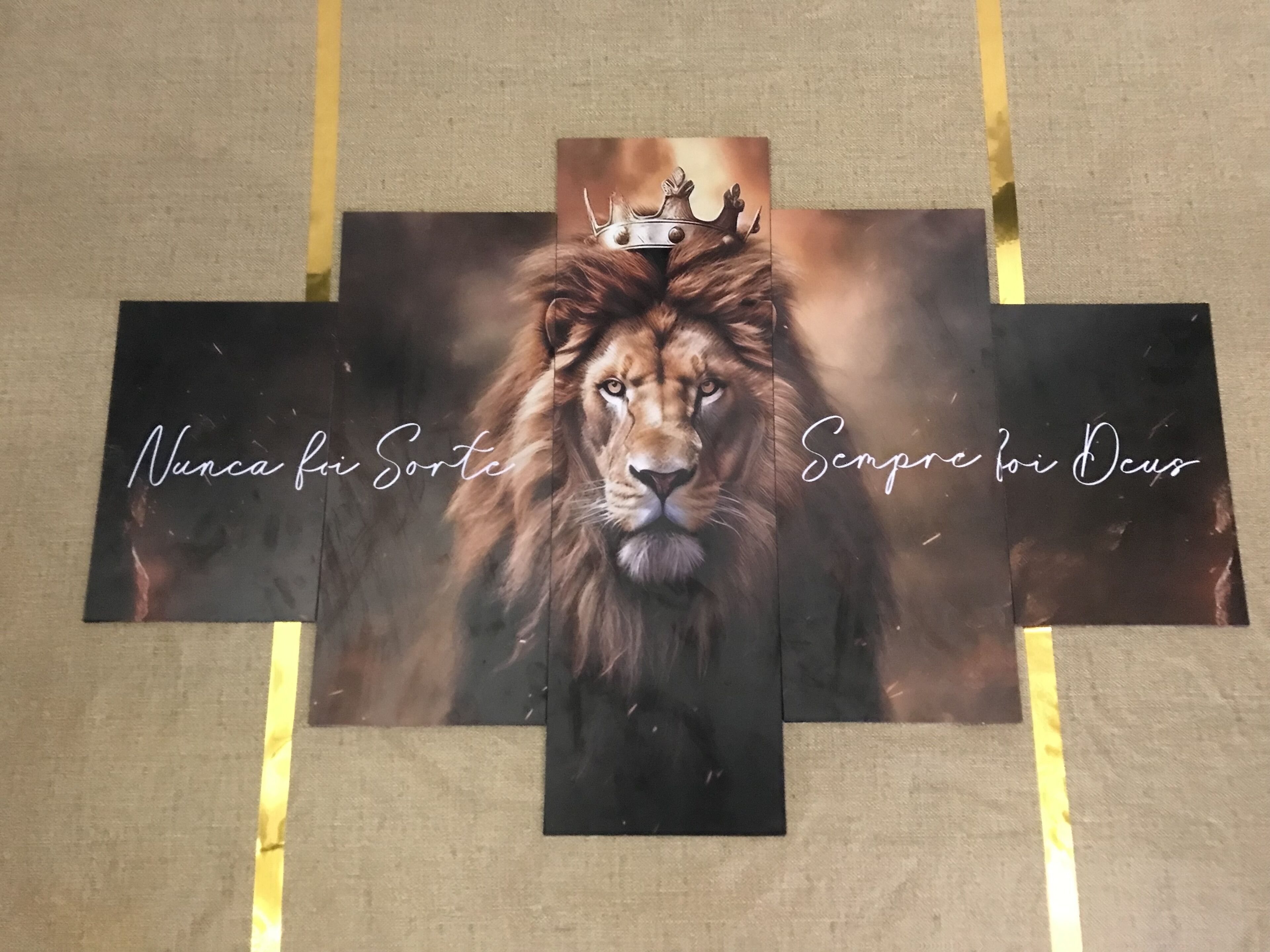A framed artwork of a lion with a crown, with text 'Nunca foi Sorte' and 'Sempre foi Deus' on either side.