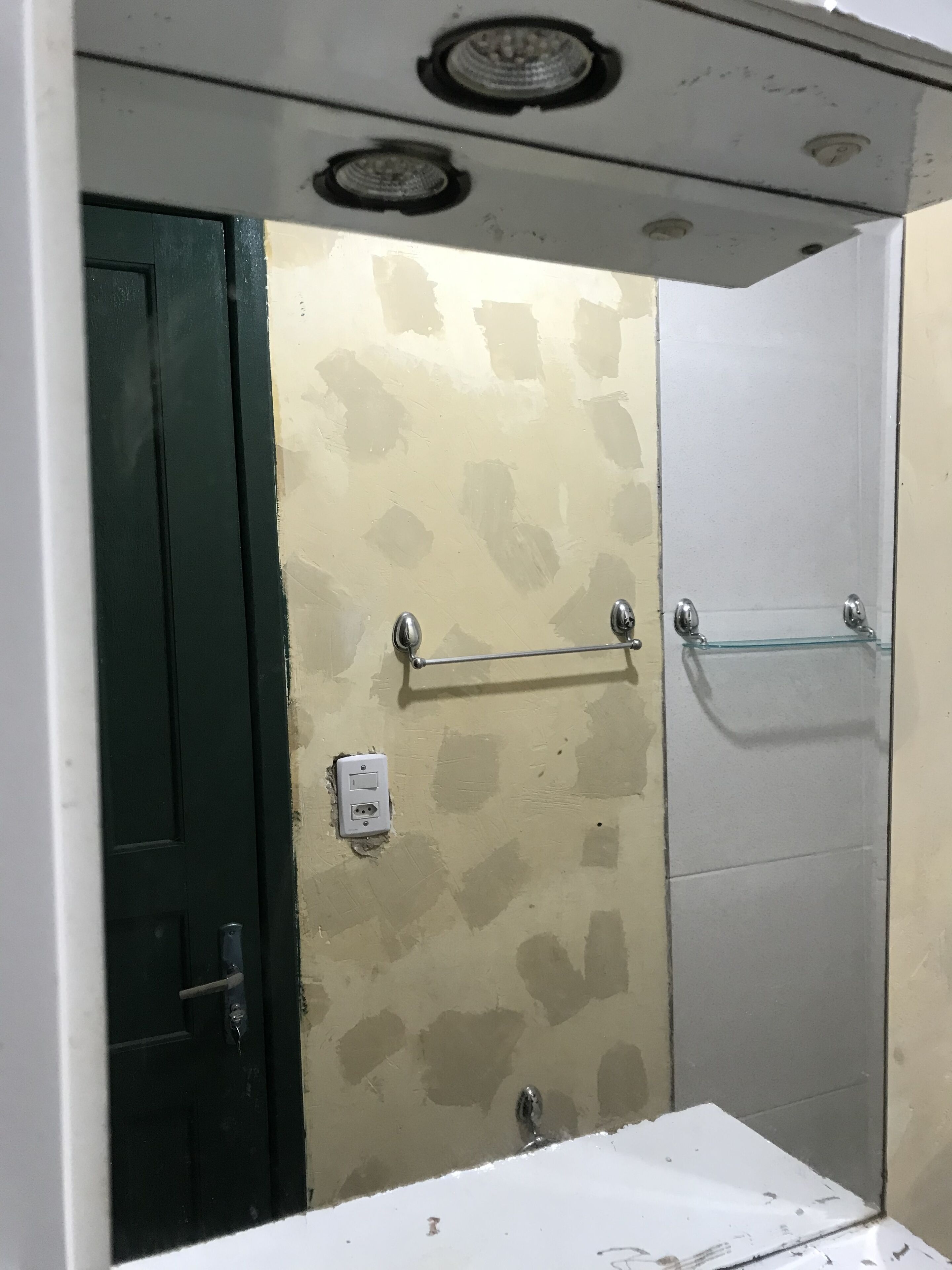 Een badkamer met een douche, een wastafel en een deur.