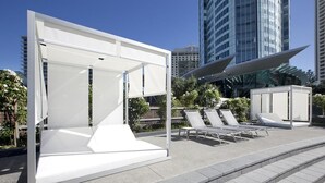 A modern outdoor lounge area with white canopies and lounge chairs, set against a backdrop of tall buildings. - Surfers Paradise Ocean view (Surfers Paradise)