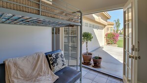 Ein Balkon mit einer Couch, einem Stockbett und Topfpflanzen.