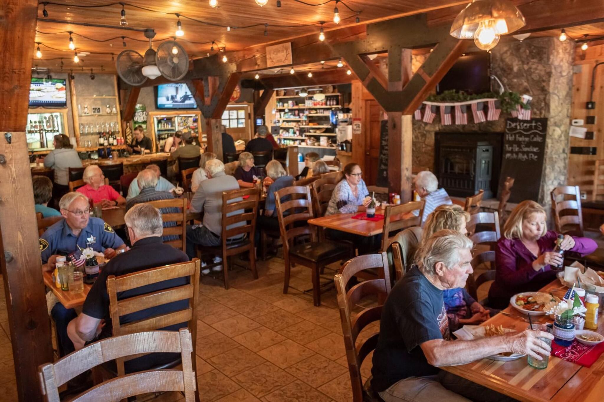 Un restaurante acogedor con mobiliario de madera y una zona de bar.