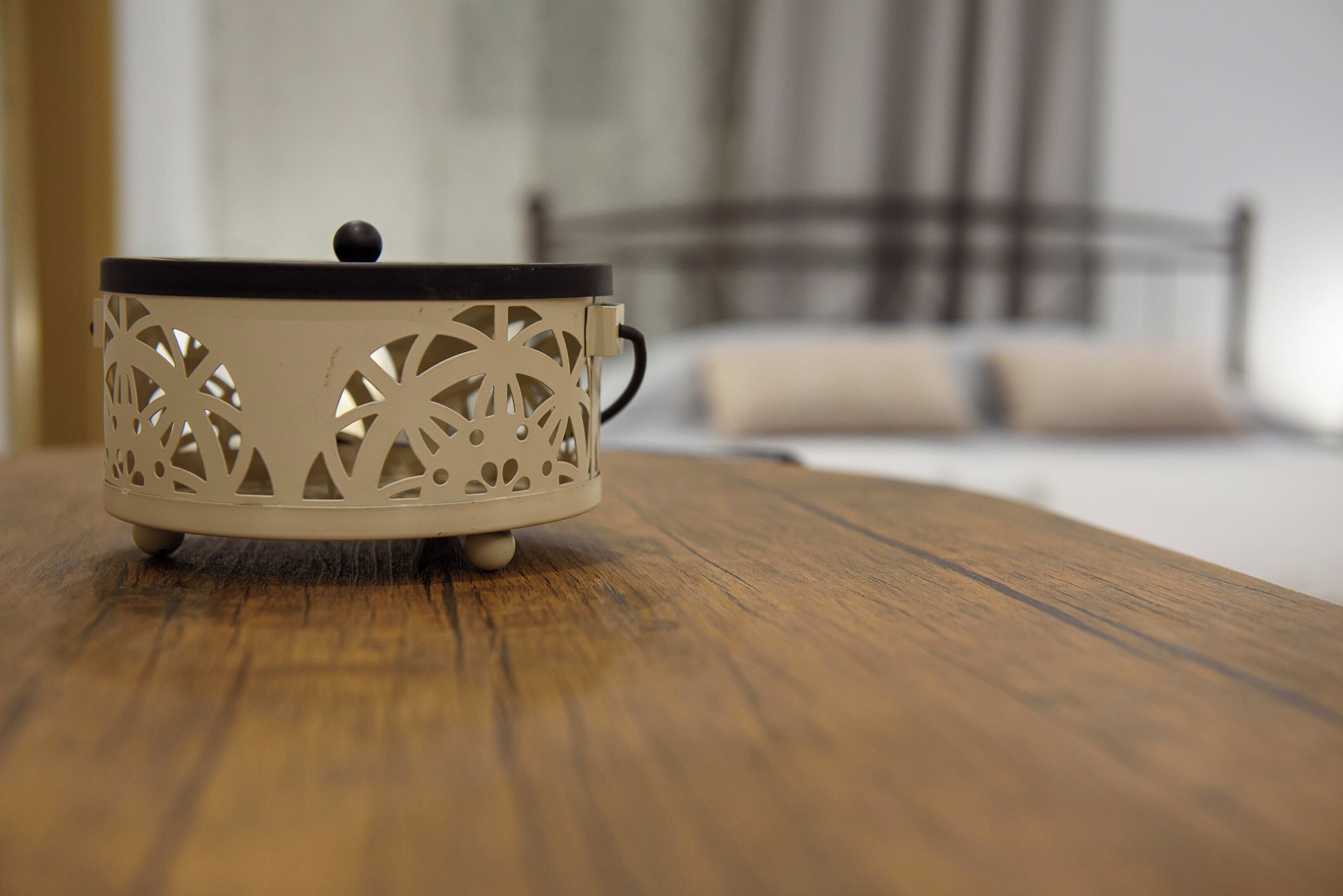 A white, intricately designed lantern on a wooden table.