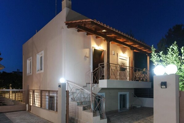 A two-story building with a balcony, a staircase, and a gated entrance.