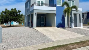 A modern two-story house with a balcony, a garage, and a driveway. - MTB  & Beach House in Cabo Rojo (boqueron)