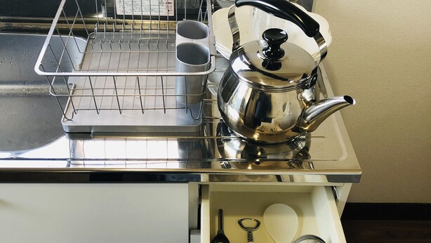 A kitchen with a stainless steel kettle, a dish rack, and a drawer containing utensils. - Ever Garden (Miyoshi)