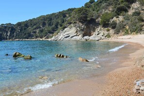 A beach with clear water, pebbly shore, and rocky cliffs. - Casa Tossa – Pool, Sea Views & A/C (6 pax) (Tossa De Mar)