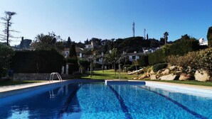 A clear blue swimming pool with a diving board, surrounded by well-maintained greenery and houses in the background. - Casa Tossa – Pool, Sea Views & A/C (6 pax) (Tossa De Mar)