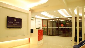 A modern hotel lobby with a reception desk, a sign for the Old Penang Hotel, and a waiting area with chairs. - Old Penang Hotel - Penang Times Square (George Town)