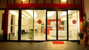 A hotel entrance with a red curtain, glass doors, and a reception desk inside. - Old Penang Hotel - Penang Times Square (George Town)